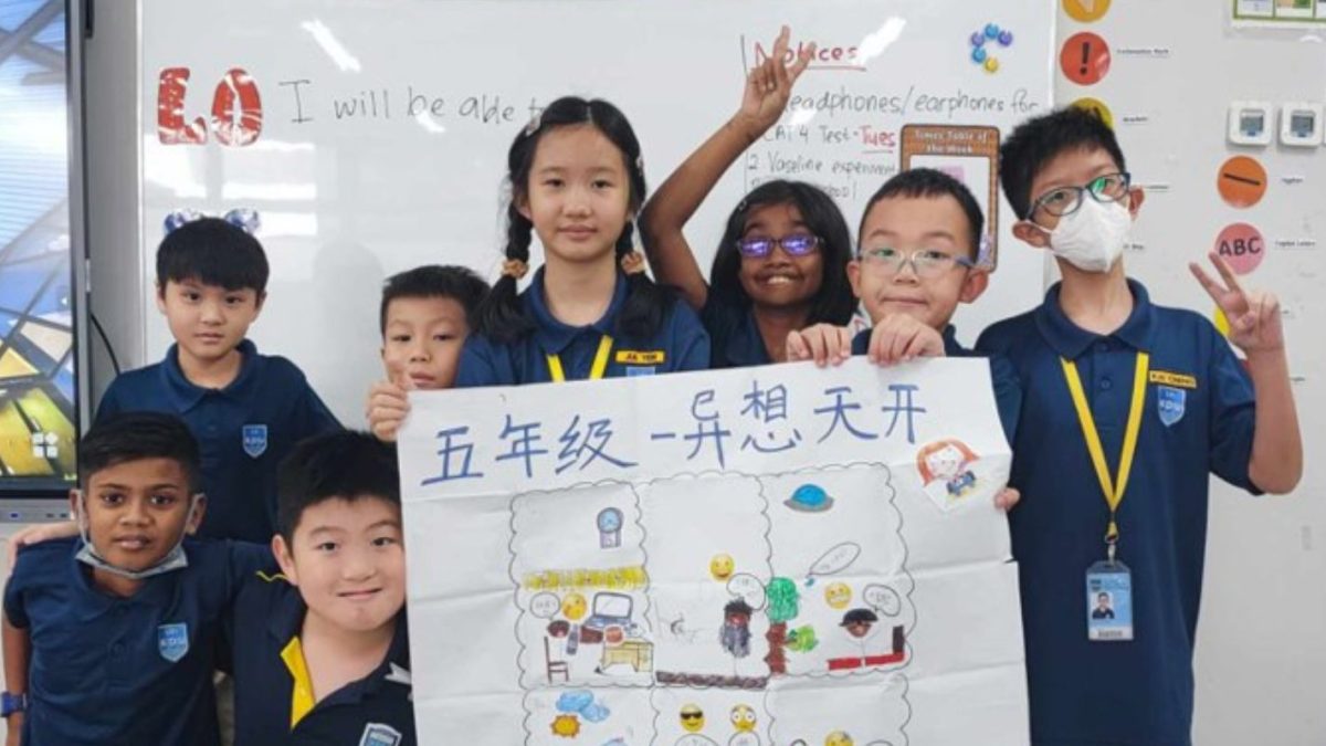Primary school students proudly display their collaborative artwork, showcasing creativity and teamwork in action.