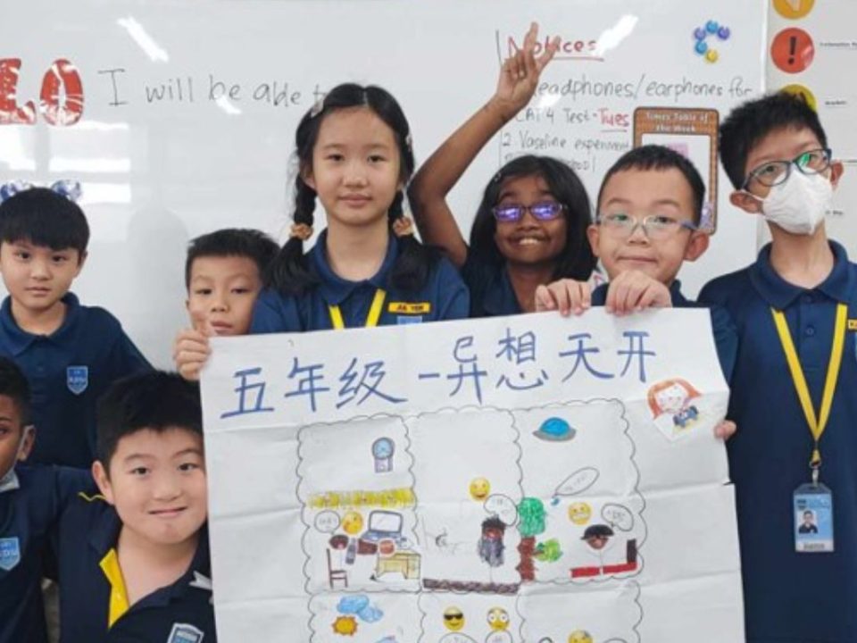 Primary school students proudly display their collaborative artwork, showcasing creativity and teamwork in action.